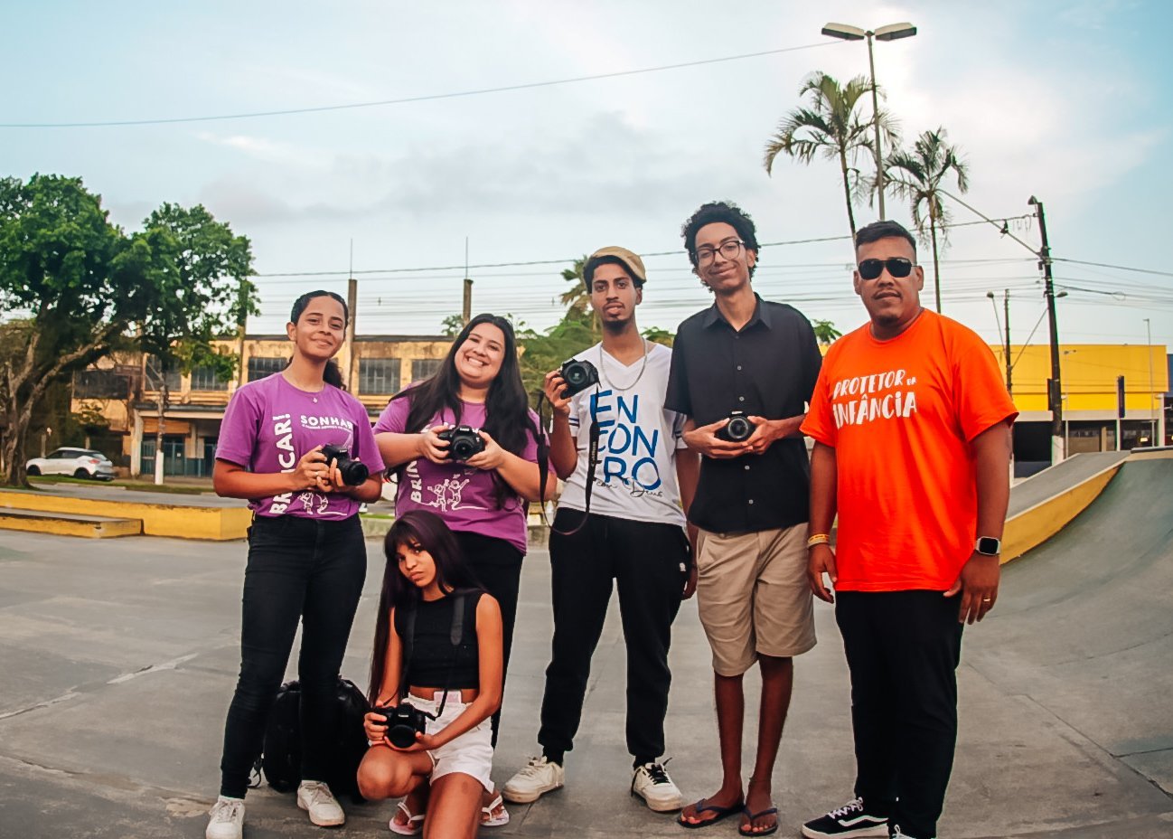 Equipe do Projeto Doulos com câmeras fotográficas nas mãos, na pista de skate de São Vicente.
